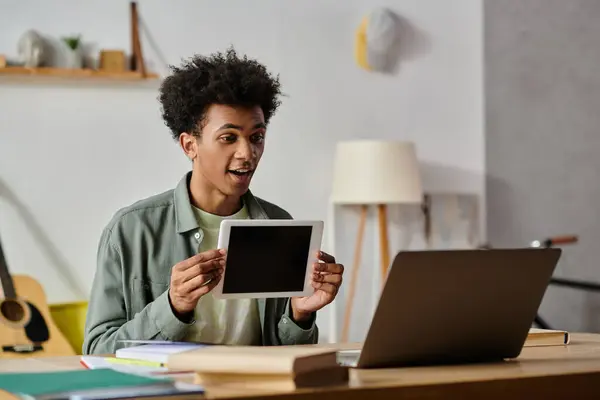 A young man holds up a laptop with a blank screen. — Stock Photo