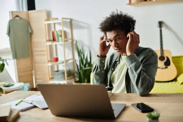 An African American man in headphones works diligently at his laptop. — Stock Photo