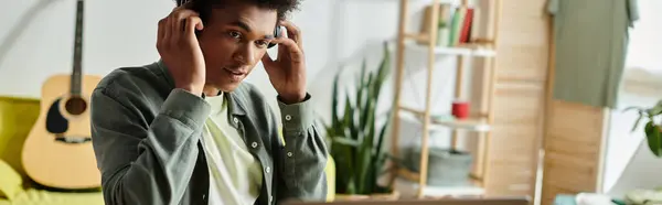 Young African American man stressed while studying at home in front of laptop. — Stockfoto