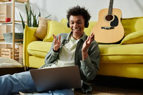 Young man, headphones on, sitting on floor. — Stock Photo