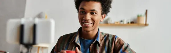 Young man, smiling, holds coffee cup. — Photo de stock