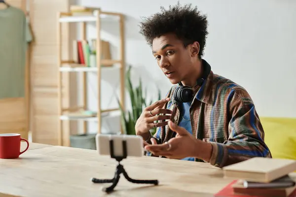 A young man sits at a table, speaking confidently. — Stock Photo
