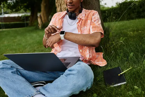 Young man, laptop, grass — стокове фото