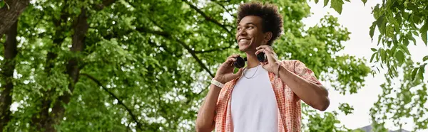 Young man using headphones in park. — Stock Photo