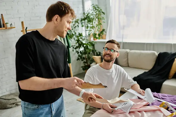 Dois homens, ambos designers, colaborando em trajes da moda em sua oficina. — Fotografia de Stock