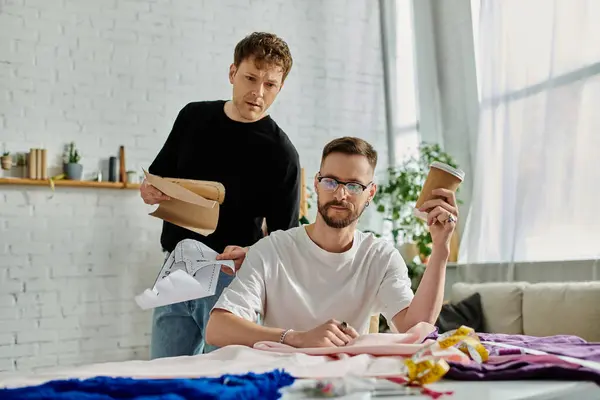 Two men, a table, and a couch in a designer workshop. — Stock Photo