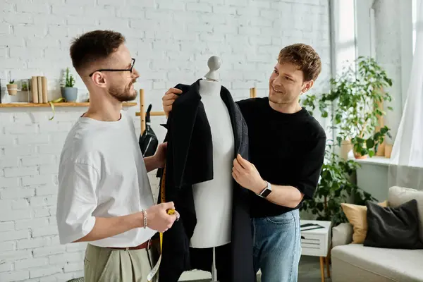 Two men, a gay couple, stand beside each other, attentively observing a dress displayed on a mannequin. — Stock Photo