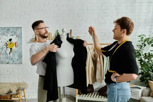A gay couple collaborates in a designer workshop, creating fashionable attire together. — Stock Photo