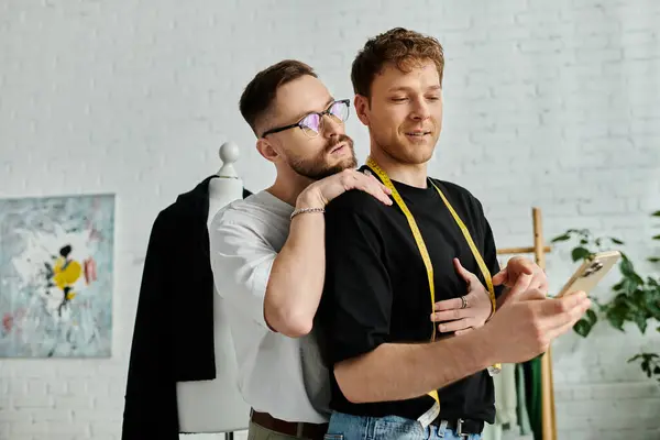 Two men, fashion designers, stand side by side in their workshop. — Stock Photo