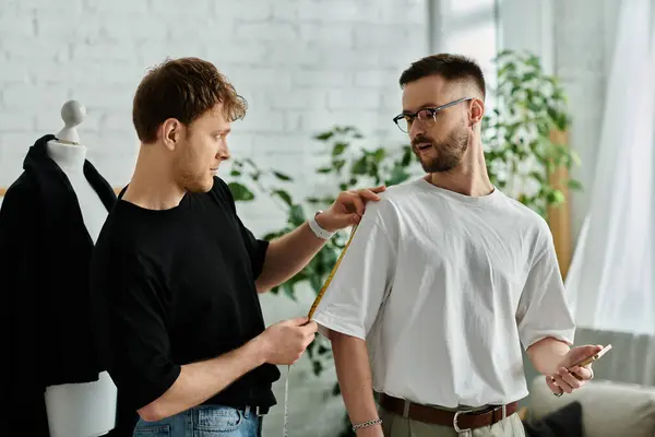 Two men collaborate in designer workshop on trendy attire. — Stock Photo