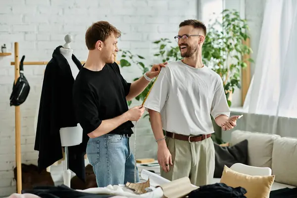 Due uomini in un laboratorio di design, che lavorano insieme su abiti eleganti. — Foto stock