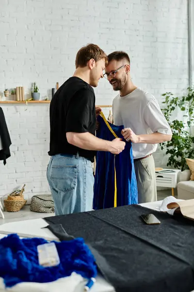 Two men, partners in both love and design, standing collaboratively in their workshop. — Stock Photo