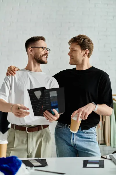 Two men collaborate on designing trendy attire in their atelier — Stock Photo