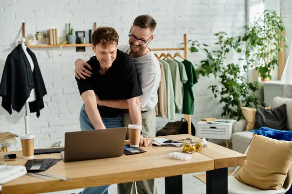 Two men passionately brainstorming at a laptop in a trendy designer workshop. — Stock Photo