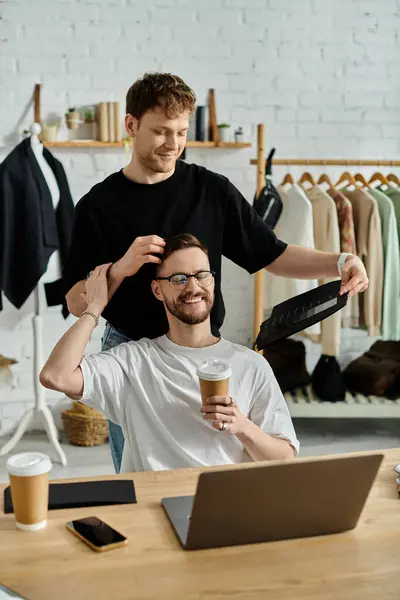 Homem sentado em um computador portátil, projetando trajes da moda com seu ente querido. — Fotografia de Stock