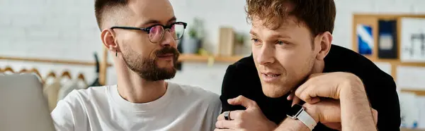 Two young men deeply engrossed in exploring a laptop screen while collaborating on a fashion design project. — Stock Photo