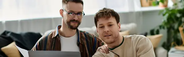 Two men in a designer workshop share ideas while looking at a laptop screen. — Stock Photo