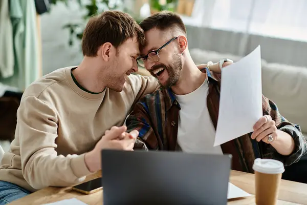 Dos hombres en el taller de diseño, trabajando juntos en el ordenador portátil - foto de stock