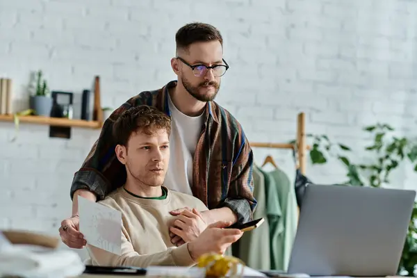Männer mit Laptop vorne, die in Designer-Werkstatt trendige Kleidung entwerfen. — Stockfoto