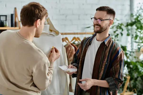 Two men discuss design ideas in a chic clothing store. — Stock Photo