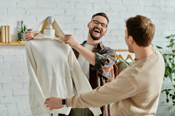 A man carefully holds a dress on a mannequin in a designer workshop. — Stock Photo
