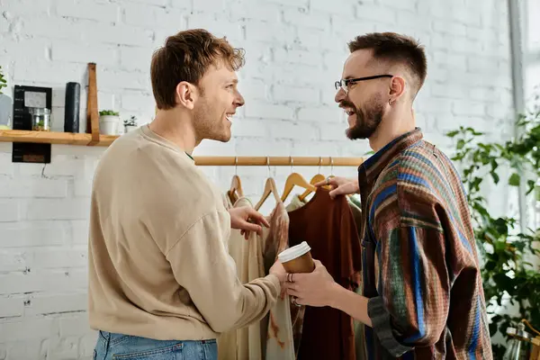 Two male fashion designers collaborate on stylish clothing in a workshop. — Stock Photo