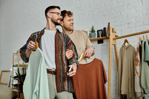 Two men, partners in love, standing in a designer workshop creating trendy attire together. — Stock Photo