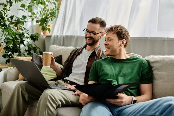 Two men sit confidently atop a modern couch, deep in creative collaboration at their designer workshop. — Stock Photo