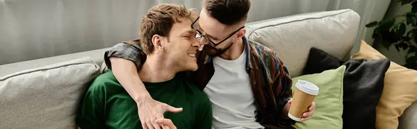 Dos hombres se relajan en un sofá en un taller de diseño, discutiendo y planeando su próxima creación de moda. - foto de stock