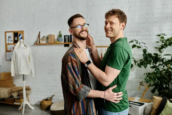 Two men, a gay couple, stand together in a designer workshop, discussing and creating trendy attire. — Stock Photo