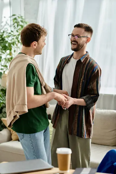 Two men, a gay couple, stand side by side in a chic living room. — Stock Photo