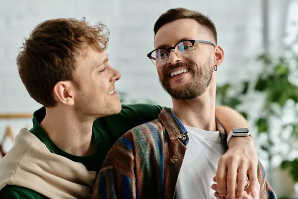 Two men sit closely in a designer workshop, passionately creating trendy attire together. — Stock Photo
