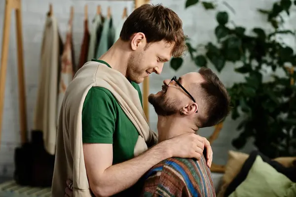 Два чоловіки, гомосексуальна пара, стоять пліч-о-пліч у дизайнерській майстерні, співпрацюючи над модними творіннями одягу. — стокове фото