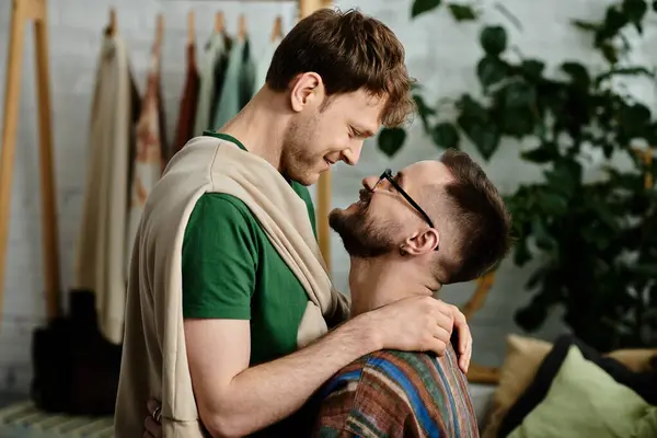 Due uomini, una coppia gay, stanno fianco a fianco in un laboratorio di design, collaborando a creazioni di abbigliamento alla moda. — Foto stock