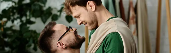 Gay couple shares a tender moment amidst their creative clothing design process. — Stock Photo