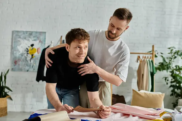 Gay men crafting clothing designs at a table in a stylish workshop. — Stock Photo