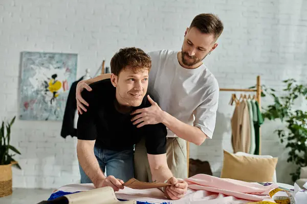 Gay men crafting clothing designs at a table in a stylish workshop. — Stock Photo