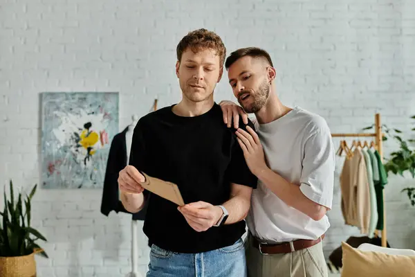 Two men in a designer workshop, collaborating on creating trendy attire. — Stock Photo