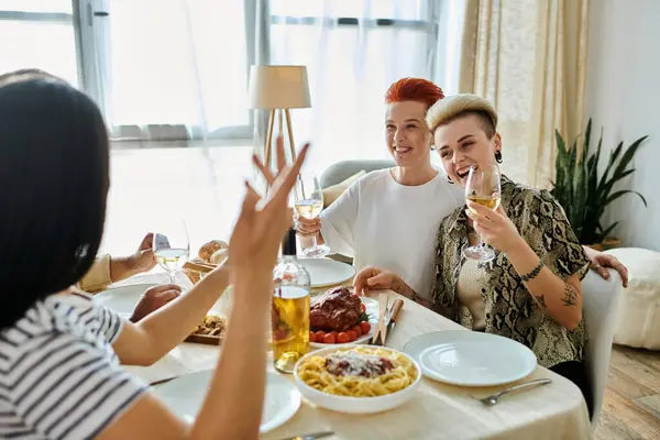 Diverse group enjoys dinner together at table. — Stock Photo
