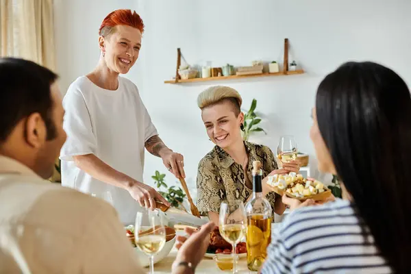 Diverse group enjoys food and drinks with a loving lesbian couple at home. — Stock Photo