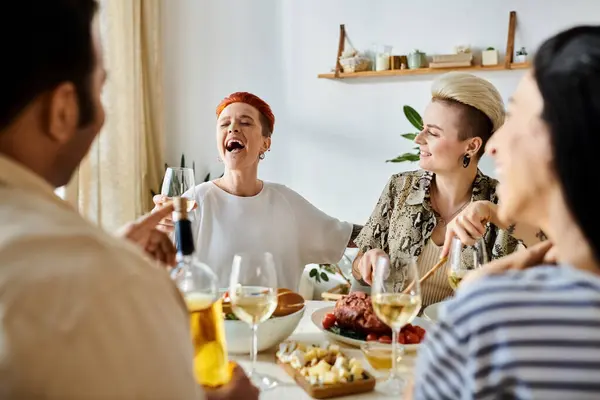 Diverse group, including a loving lesbian couple, enjoy a meal together. — Stock Photo