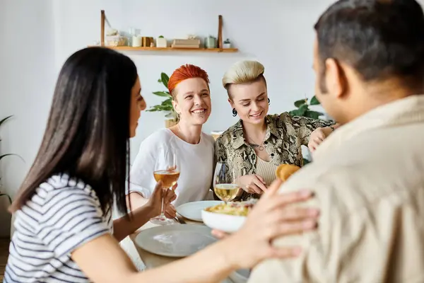 A diverse group of friends sharing a meal around a dinner table at home. — Stock Photo