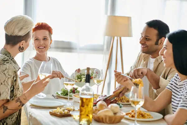 A diverse group of friends enjoy a meal together at a dinner table hosted by a loving lesbian couple. — Stock Photo