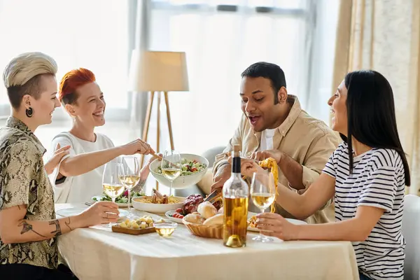 A diverse group of people sitting around a table, eating delicious food and enjoying each others company. — Stock Photo