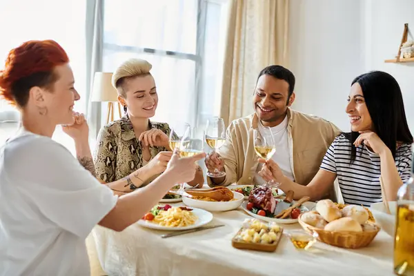 Vielfältige Gruppe genießt Essen und Trinken an einem Tisch. — Stockfoto