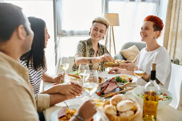 Diverse group of people enjoying delicious food around a table. — Stock Photo