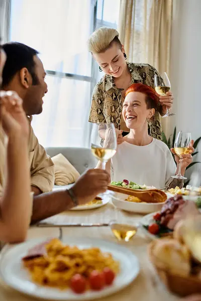 A diverse group enjoys a dinner gathering around a table at home. — Stock Photo