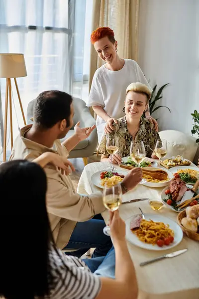 Diverse group enjoying a meal together at a table. — Stock Photo