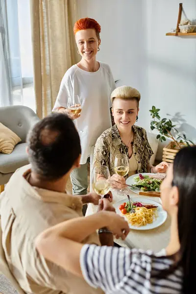 Grupo diverso desfruta de refeição caseira com riso e conversa. — Fotografia de Stock