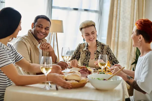 A group of diverse friends, including a loving lesbian couple, enjoying a meal together at a table. — Stock Photo